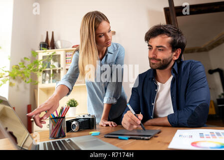 Graphic designers working on the project. Couple of freelancers working at home. Stock Photo