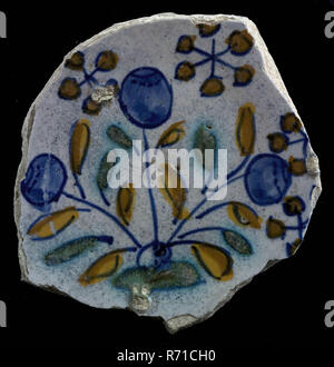 Fragment majolica dish, polychrome, three blue flowers or berries on piece of land, dish plate crockery holder earth discovery ceramic earthenware glaze, Fragment majolica dish orange green and blue on white three blue flowers possible blueberries on piece of land around it snow crystal-like motifs archeology Rotterdam tulip tuliprasernie decorate food Soil discovery Rotterdam 1940. Stock Photo