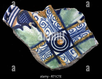 Fragment of majolica dish, orange and green and blue on white, cross shape and in between leaves, in the middle circles, cable border, dish plate crockery holder earth discovery ceramics earthenware glaze, total with , archeology Rotterdam decorate soil discovery Rotterdam 1941. Stock Photo