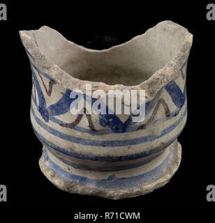 Fragment majolica albarello, ointment jar, polychrome decoration on white background, albarello holder earthenware pottery earthenware glaze tin glaze lead glaze, hand turned baked glazed ornamented baked Foot fragment of albarello necking above the foot Orange shard glazed except the bottom of the bottom Polychrome decoration consisting of zigzag pattern in blue and purple in the middle blue bands archeology Rotterdam health care pottery packing ointment medicine drug pharmacy craft Botemvondst Rotterdam 1940. Stock Photo