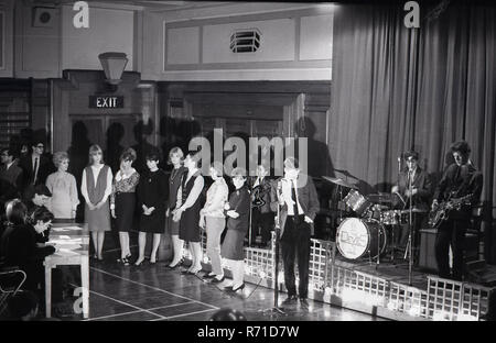 1960s, historical, music auditions, young women having an audition as a singer at a venue, with a band or backing group on a stage. Stock Photo