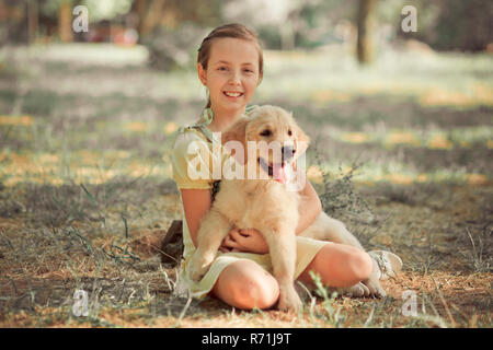 Retriever pup Lovely scene cute young teen girl enjoying posing summer time vacation with best friend dog ivory white labrador puppy.Happy airily care Stock Photo