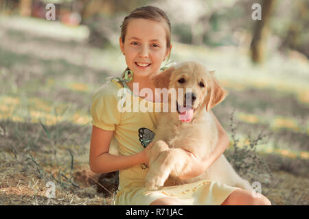 Retriever pup Lovely scene cute young teen girl enjoying posing summer time vacation with best friend dog ivory white labrador puppy.Happy airily care Stock Photo