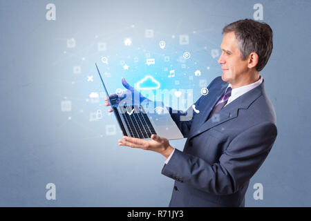 Man holding laptop projecting notifications, symbols and information based on cloud technology system  Stock Photo