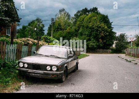 Mir, Belarus - August 30, 2016:  Old rusty sedan car BMW 3 abandoned on street. Stock Photo
