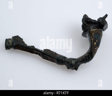 Bronze fibula or mantle pin decorated with enamel, part of the needle remains, fibula fastener soil find bronze metal enamel, cast whipped drawn bronze fibula or mantelpiece. Curved back. At the widest piece inlaid with enamel archeology Spijkenisse Roman time early Middle Ages dress fastening pins Soil discovery Spijkenisse. Stock Photo