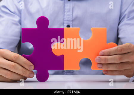 Person Holding Two Jigsaw Puzzle Stock Photo