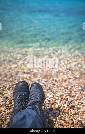 Trekker feet on the stony beach Stock Photo