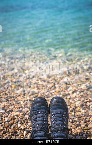 Trekker feet on the stony beach Stock Photo