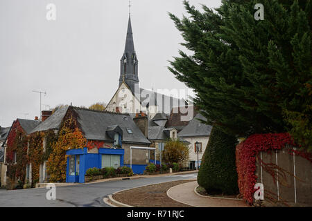 Side view of a typical small street and buildings in a village on a fall day with the church and ivy walls Stock Photo