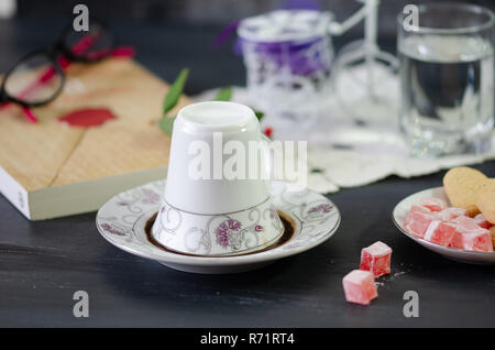 Turkish Coffee in White Porcelain Cup and Turkish Delight.Single overturned coffee cup on the plate for coffee divination Stock Photo
