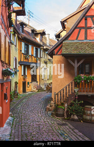 Colorful winding street with  old houses decorated for Christmas,  Eguisheim, north-eastern France. Stock Photo