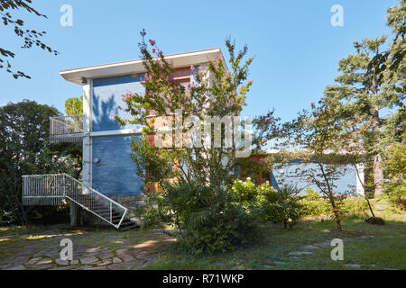 Villa with blue tiled wall and garden in a sunny summer day, clear blue sky Stock Photo