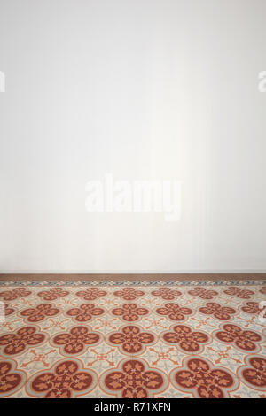 Empty room with white wall and ancient tiled floor in a renovated apartment Stock Photo