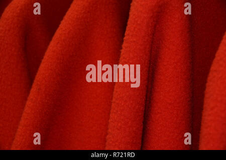detail shot of red sleeves from some fleece jackets on hanger, colorful polar fleece jackets on a hanger macro shot made of recycled plastic bottles Stock Photo