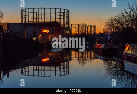 London, England, UK - February 24, 2016: Disused gasometers and a large Sainsbury's supermarket store are reflected in the waters of the Grand Union C Stock Photo