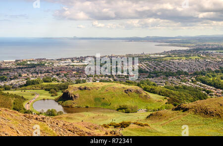 Houses of Portobello, Musselburgh, Presponpans and Cockenzie line the Firth of Forth Coast as viewed from above Dunsapie Loch on Arthur's Seat hill in Stock Photo