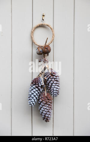 Festive christmas pine cone door hanging decoration on a cottage door in Burford. Cotswolds, Oxfordshire, England Stock Photo