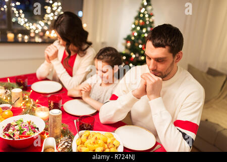 family praying before meal at christmas dinner Stock Photo