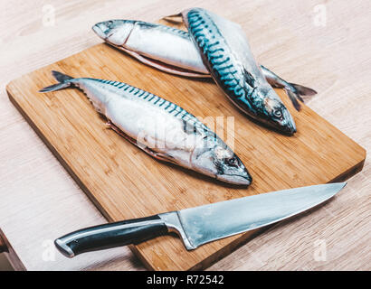 raw mackerel fish on wooden cutting board with a knife Stock Photo