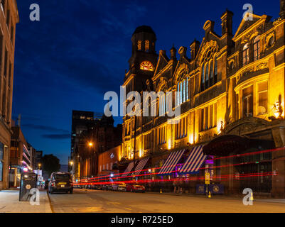 Manchester, England, UK - July 1, 2018: Traffic leaves light trails on Peter Street outside Albert Hall, a former Methodist Central Hall turned nightc Stock Photo