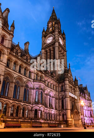 Manchester, England, UK - July 1, 2018: The gothic exterior and clock tower of Manchester Town Hall is lit at night on the city's Albert Square. Stock Photo