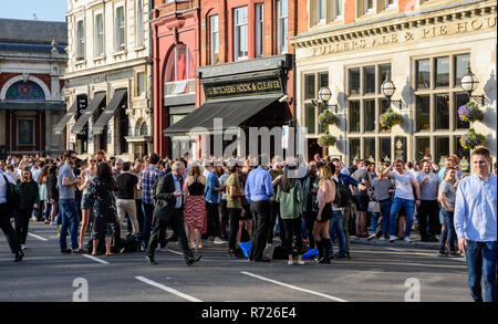 London, England, UK - April 20, 2018: Crowds of after-work drinkers socialise outside pubs and bars near Smithfield Market in the City of London on a  Stock Photo