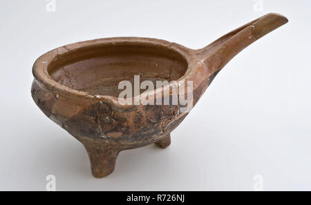 Pottery saucepan on three legs, with pouring spout and slanted, scalloped handle, saucepan cooking pot crockery holder kitchenware soil find ceramic earthenware glaze lead glaze, hand turned molded glazed baked saucepan of red earthenware internally glazed pouring spout stem three legs and base of plaster turnings Slanted upward handle with scalloped end Receding upper edge archeology Valckensteyn Poortugaal Albrandswaard indigenous pottery cooking kitchen preparing food Soil discovery: canal at kitchen castle Valckensteyn at Poortugaal now Albrandswaard 1961. Stock Photo