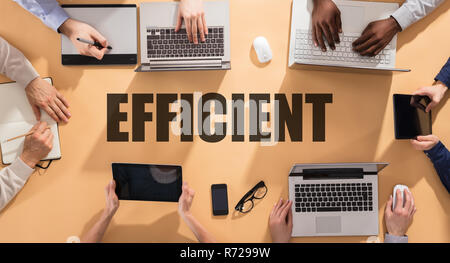 Efficient Word Surrounded With Businesspeople Using Electronic Gadgets On Table Stock Photo