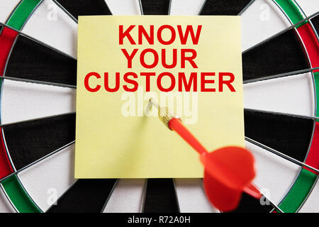 Close-up Of Dart On Yellow Adhesive Note With Know Your Customer Text Stock Photo
