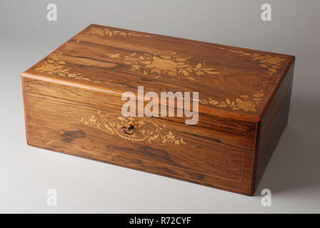 Wooden writing box with flower decoration, inside writing surface, storage compartments and two ink bottles, writing box box casket wood rosewood metal closed, inlaid Wooden rectangular writing box for use on the table with lock and matching key If the lid is opened, continuous slanting desk is created with hinge in the middle; the wooden tabletop is covered with green paper background with gold trim and corner figures wood framed; underneath this writing surface there is storage space on both sides which can be reached by hinging the surface openly; above the writing surface there is an elong Stock Photo