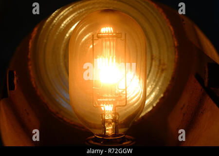 close up tungsten stage lightbulb filament glowing when switched on Stock Photo