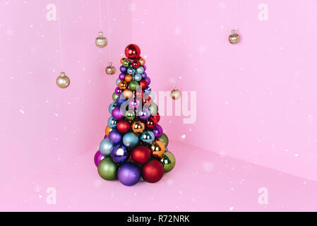 Christmas tree made of ball decoration on pink background. Stock Photo