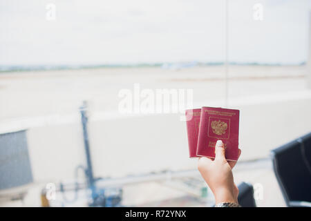 BARCELONA, SPAIN - AUGUST 10, 2018: Two russian passports in hand. Russian official document on wooden background Stock Photo