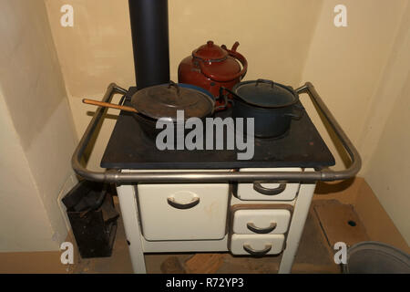 Old-fashioned kitchen stove, oven with kettles in a rustic kitchen chalet. Stock Photo