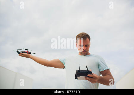 A process of launching the quadcopter drone with camera, operator launches quadcopter uav, unmanned aerial vehicle flying Stock Photo