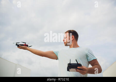 A process of launching the quadcopter drone with camera, operator launches quadcopter uav, unmanned aerial vehicle flying Stock Photo