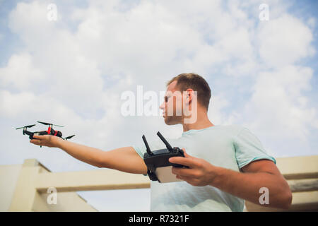 A process of launching the quadcopter drone with camera, operator launches quadcopter uav, unmanned aerial vehicle flying Stock Photo