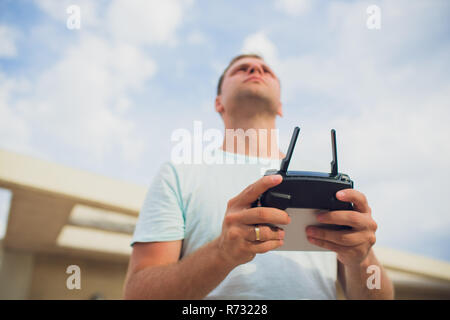 A process of launching the quadcopter drone with camera, operator launches quadcopter uav, unmanned aerial vehicle flying Stock Photo