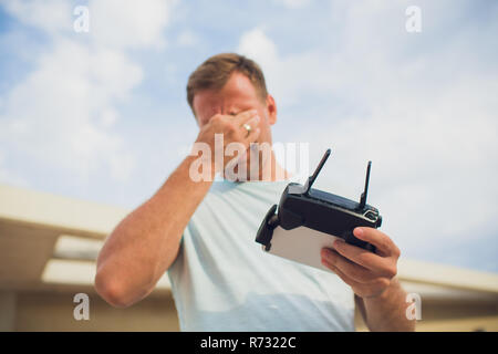 A process of launching the quadcopter drone with camera, operator launches quadcopter uav, unmanned aerial vehicle flying saddened by the result Stock Photo
