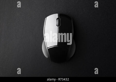 Black Wireless Optical Mouse on Black Surface Seen from Above Stock Photo