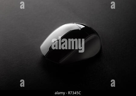 Black Wireless Optical Mouse on Black Surface Seen from Above Stock Photo