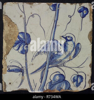 Blue tile of chimney pilaster with 13 tiles, left looking bird on grape branch and dragonfly, chimney pilaster tile pilaster footage fragment ceramics pottery glaze, Three blue tiles with bird dragonflies butterfly grape leaves possible from the same chimney pilaster with 13 tiles tree of bunches of grapes with birds grain leaves foot unknown. Stock Photo