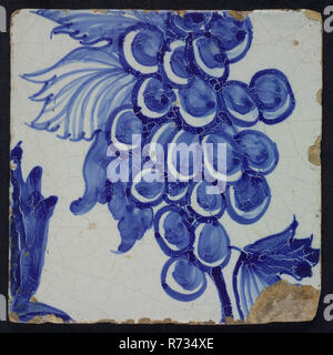 Blue tile with grape leaves, grape bunch and tendrils of pilaster with 39 tiles, tree of bunches of grapes among which birds, insects, tile pilaster footage fragment ceramic pottery glaze, Coarsely painted image of grape leaves and grapes, in black paint 27. Stock Photo