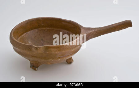 Pottery saucepan on three legs, with pouring spout and slanted handle, saucepan cooking pot crockery holder kitchenware soil find ceramic earthenware glaze lead glaze, hand turned molded glazed baked Saucepan with pouring spout red shard fully glazed three-legged stem of gypsum rings. Bowl-shaped bottom and top edge with collar archeology Valckensteyn Poortugaal Albrandswaard indigenous pottery cooking cuisine food nutrition food preparation Soil discovery: canal at kitchen castle Valckensteyn at Poortugaal now Albrandswaard 1961. Stock Photo