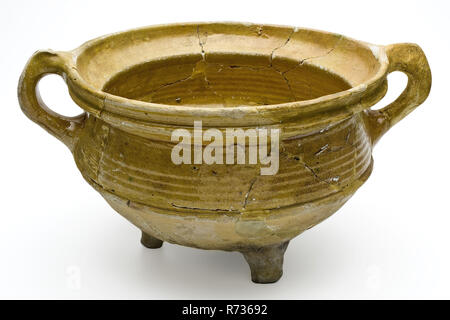 Yellow pot on three legs, with two pinched ears, lid edge, grape cooking pot crockery holder kitchenware earth discovery ceramic earthenware glaze lead glaze, hand turned set glazed baked Cooking pot white shard yellow glaze two pinched ears of which one in plaster three legs of which one in gypsum rings . Double conical in shape with semi-round bottom. Groove along the upper edge archeology Valckensteyn Poortugaal Albrandswaard indigenous pottery kitchen cooking stoves nutrition food preparation Soil discovery: castle Valckensteyn in Poortugaal now Albrandswaard 1961-1962. Stock Photo
