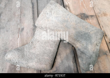 felt boots on a wooden floor. Valenki traditional Russian winter footwear in countryside. Stock Photo