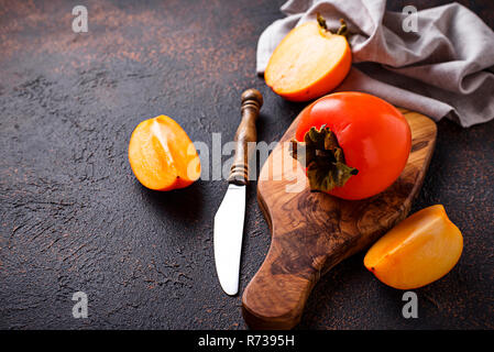 Fresh ripe persimmon on cutting board Stock Photo
