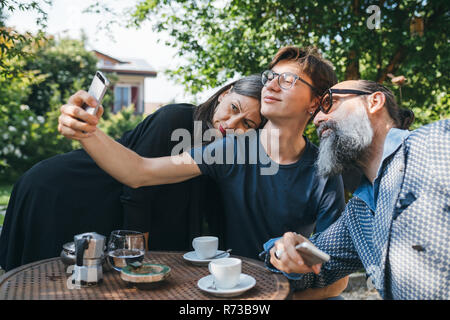 Family taking selfie over coffee in patio