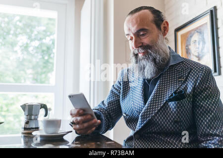 Man texting over coffee in kitchen